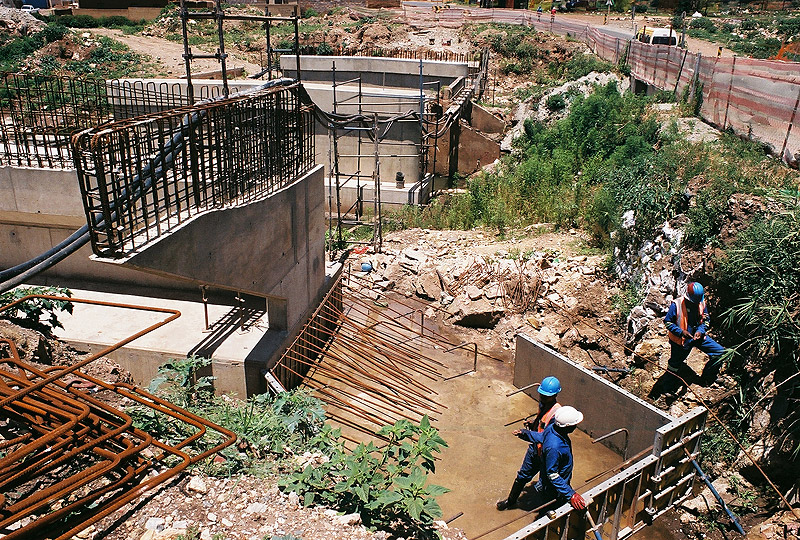 Engineering crew working on a bridge abutment and culvert on a live highway rehabilitation site